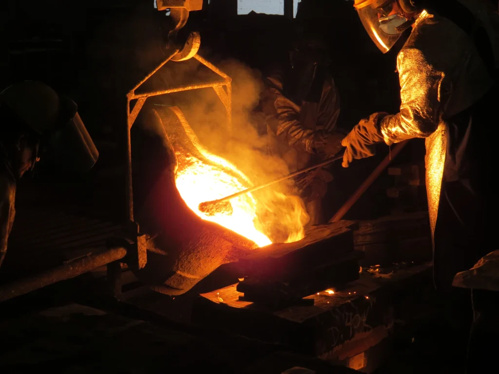 Blacksmith holding glowing steel at the forge