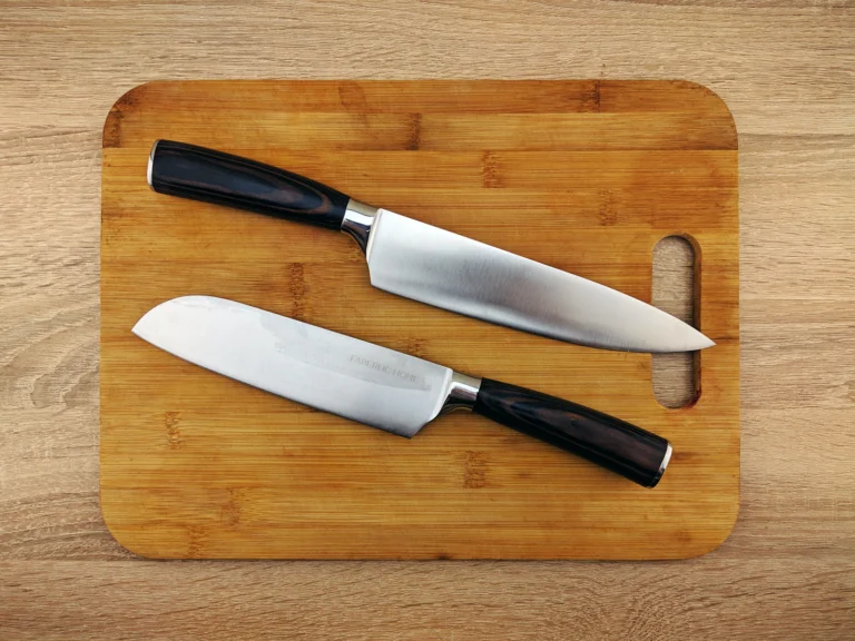 Two chef knives lying on a wooden cutting board